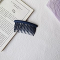 Detail of navy blue matte hair comb with rounded teeth for styling on a white textured surface - Round Head Afro Comb / Navy Blue
