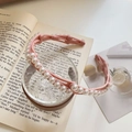 Détail d'un serre-tête rose rétractable avec perles sur un verre d'eau glacée clair - Ton Rose avec Perle