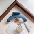 Elegant matte blue large arch hair claw clip shown on minimalist aesthetic background - Navy Blue
