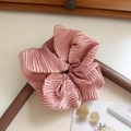 Detail of pink satin scrunchie with silk-like texture and soft pleats on wooden frame - Pink