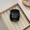 Glossy black resin hair claw clip with rectangular design on a wooden tray - Small / Black