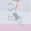 Dettaglio di un portachiavi a tema calcio con perle di silicone e nappa bianca decorativa - Calcio