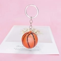 Realistischer orangefarbener Basketball Schlüsselanhänger auf einem rosa Hintergrund - Basketball