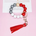 Detail of beaded keychain bracelet with red leather tassel and hexagonal wood bead - Red