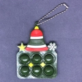 Dettaglio di un portachiavi pop-it a forma di campana di Natale verde con motivi a stella - Campana di Natale