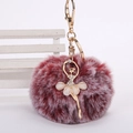 Détail du pompon en fausse fourrure bordeaux avec charm ballerine dorée et strass brillants - Pompon de 8 cm / Bicolore Rouge Vin