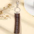 Close-up of geometric ethnic floral embroidery on a colorful woven fabric keychain strap - Brown Diamond(D)