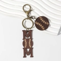Close-up of MOM wooden keychain with baseball pattern on white stone background - Baseball Style