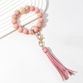 Detail of pink plaid wooden beaded keychain bracelet with golden ring and PU tassel - Pink