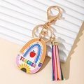 Détail d'un pendentif en bois pour enseignant avec pompon coloré et motifs de tournesol - Plaque Ovale Avec Gland