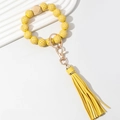 Detail of yellow plaid wooden beaded keychain with gold metal clasp and long PU tassel - Yellow