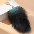 Dettaglio di portachiavi a coda di volpe in peluche extra large con sfumatura blu e nera - Verde