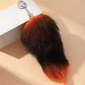 Dettaglio di un portachiavi a coda di volpe gigante rosso e nero con finta pelliccia - Arancione