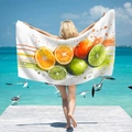 Microfiber beach towel with citrus fruit print held by a model on a sunny pier beach - 70x150cm / Fresh Citrus