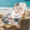 Microfiber beach towel with seashell and coral print resting on a beach lounge chair - 70x150cm / Ocean Shell Coral