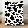 Detalle de una manta grande de franela con estampado de vaca negro y blanco en un salón - 100x150cm / Estampado de Vaca en Blanco y Negro