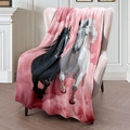 Roze flanellen deken met zwart-wit paardenpatroon over een zachte bank gedrapeerd - 100x150cm