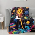 Cartoon space flannel blanket with sun and planets draped on a cozy grey sofa - 100x150cm