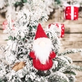 Gnomo di Natale con paillettes, cappello rosso e barba bianca appeso all'albero innevato - Stile E Gnomo Rosso