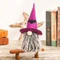Handmade Halloween gnome plush with purple bat hat on a rustic wooden bench display - Purple Bat Gnome