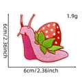 Close-up of strawberry snail embroidery patch with fine needlework and vibrant colors - Strawberry Snail