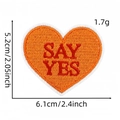 Détail de l'écusson brodé en forme de cœur orange avec texte SAY YES rouge et bord blanc - Say Yes (Patch Cœur 16#)