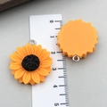 Détail macro de pendentifs tournesol en résine avec anneaux pour création de bijoux - Grande Marguerite Tournesol Orange-Jaune (23836)