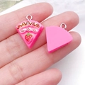 Macro shot of miniature pink strawberry cake resin pendant with silver hook for DIY crafts - Rose Red