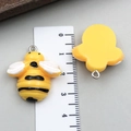 Vue détaillée de petits pendentifs abeilles en résine avec échelle de mesure de 2,5 cm - Grande Abeille en Résine Jaune (24116)