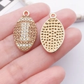 Detail of oval pendants with rhinestone pavé and honeycomb hollow back design - Champagne Drip Oil Rhinestone Rugby (24943)