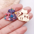 Détail macro de breloques chat en émail coloré avec dos en métal doré et motifs floraux - Violet (24894)