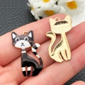 Gros plan de pendentifs chats en émail noir et blanc pour la création de bijoux DIY - Chat Raton Laveur Noir Blanc (22647)