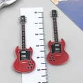 Detalle de dos dijes de guitarra eléctrica roja en acrílico con regla de medición - Guitarra de Música Impresa a Doble Cara Roja (24046)