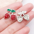Macro view of strawberry charm pendants showing enameled finish and alloy base details - Silver Finish Red Enamel Strawberry Cherry (23458)