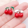 Macro detail of cherry-shaped alloy pendants on hand for DIY jewelry making - Silver Finish Red Enamel 3D Connected Cherry (23459)