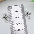 Zwei silberne Hip-Hop-Kreuzanhänger mit Hohlmuster, ca. 20mm groß, neben einem Lineal - Hohlkreuz (18724) / 11x16mm