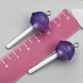Détail macro de breloques sucettes en résine violette pailletée avec mesures sur une règle - Sucette Résine Transparent Violet (24171)