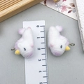 Detailed macro view showing a pair of white flocked unicorn charms with a size ruler - Unicorn Style (23139) / White Pink