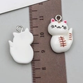 Detailed view of 2cm white resin cat charms with painted whiskers and metal rings - 22x15x7mm / White Resin Cat