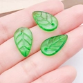 Tre ciondoli a foglia in acrilico verde traslucido per gioielli fai da te su mano - Foglia di Fragola Verde Scuro