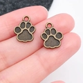 Gros plan de pendentifs pattes en alliage de bronze tenus sur les doigts - Style de Patte de Chat à Rayures Antique (20611)