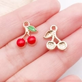 DIY cherry pendant charm in red enamel finish held in hand to show small size - Red Enamel Single Sided Small Cherry (11052)