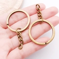 Close-up of bronze-plated keychain rings with durable 4-link chains in a hand view - Antique Bronze with Chain Style (25825)