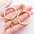 Close-up of dual gold-plated metal keychains with chain links held to show size - Gold with Chain Style (25824)