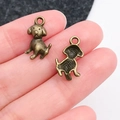 Pendentif chien en bronze vintage pour bijoux DIY présenté dans la main - Style de Chien Assis en Bronze Antique (20578)