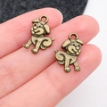 Pendentif chien en bronze antique pour bijoux DIY présenté sur les doigts - Style de Chien Souriant en Bronze Antique (20579)