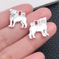 Silver pug dog charms for DIY jewelry making shown on finger for scale - Bright Silver Pug 16x15mm (20537)
