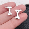 Handheld silver bone-shaped metal charm with top loop for DIY jewelry and keychains - Bright Silver Bone 17x11mm (20542)