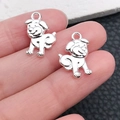 Silver alloy puppy dog charms for DIY jewelry making held in hand for scale - Bright Silver Smiling Dog 17x11mm (20548)