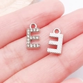 Silver letter E pendant with white crystals for DIY jewelry making on hand palm - Letter E